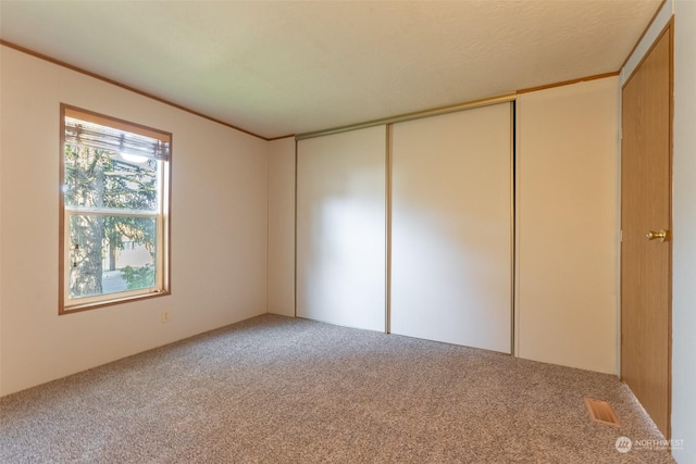 unfurnished bedroom featuring a closet and carpet flooring