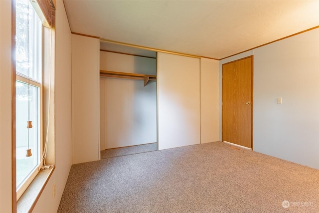 unfurnished bedroom with carpet and a closet