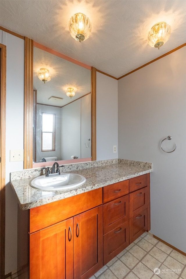 bathroom with vanity, crown molding, and a textured ceiling