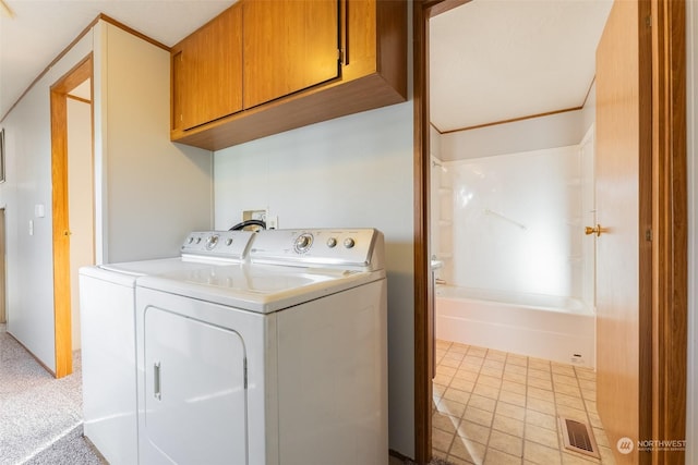 laundry area with independent washer and dryer, cabinets, and light colored carpet