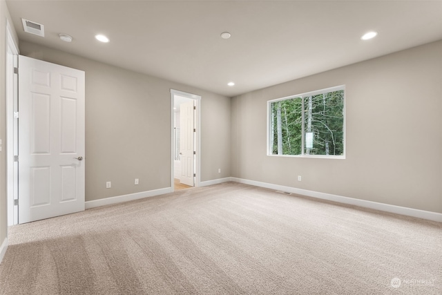 unfurnished room featuring light colored carpet