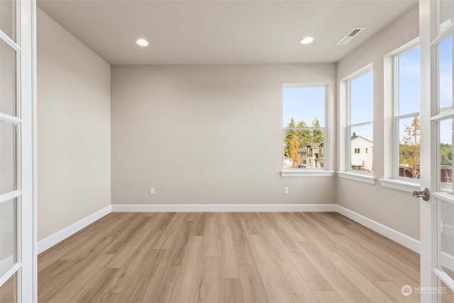 empty room featuring light wood-type flooring and french doors