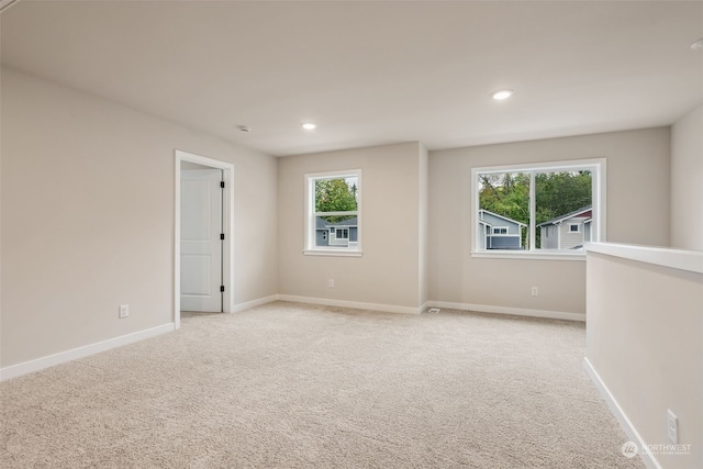 empty room featuring recessed lighting, baseboards, and light colored carpet