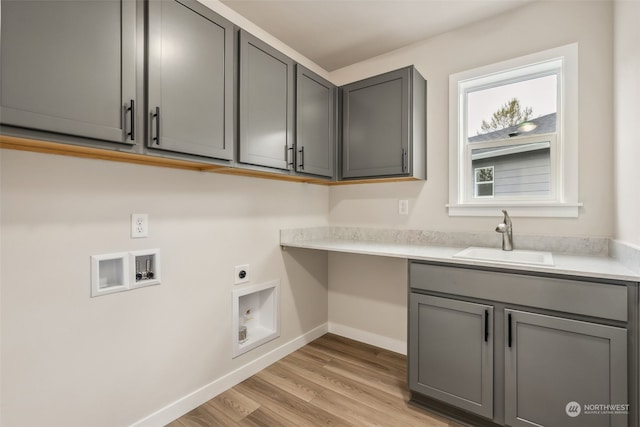 clothes washing area featuring washer hookup, light wood-style floors, cabinet space, hookup for an electric dryer, and a sink