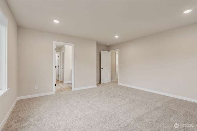 unfurnished bedroom with recessed lighting, light colored carpet, and baseboards