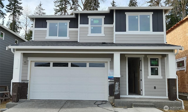 view of front of property with a garage, roof with shingles, and concrete driveway