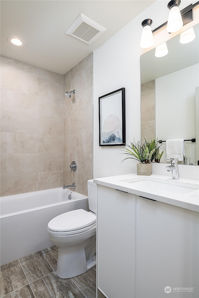 full bathroom with tiled shower / bath combo, toilet, and vanity