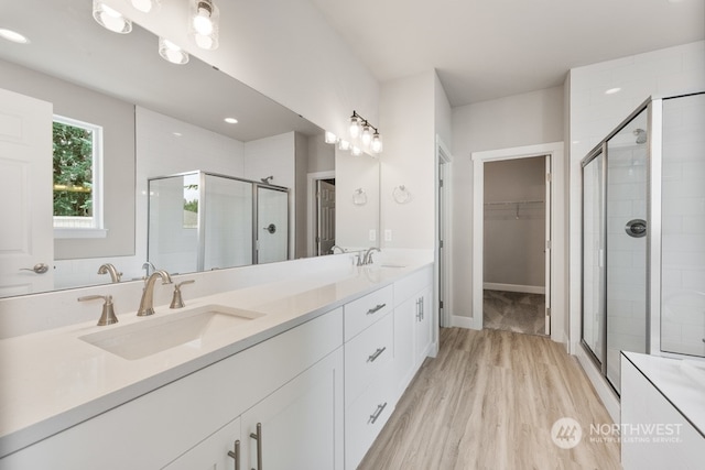 bathroom featuring a shower with shower door, wood-type flooring, and vanity