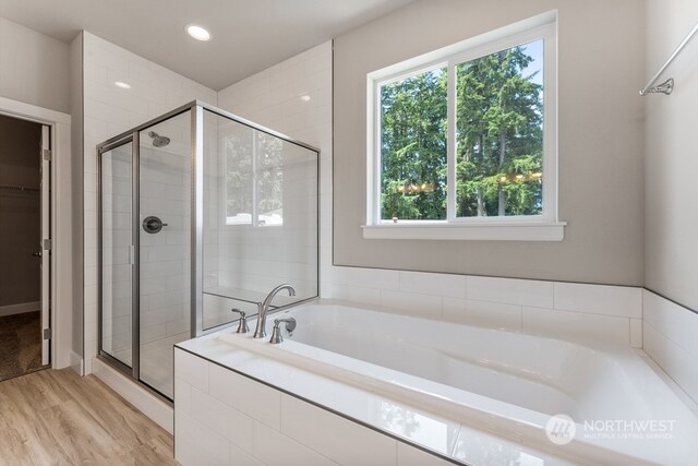 bathroom featuring hardwood / wood-style flooring and separate shower and tub