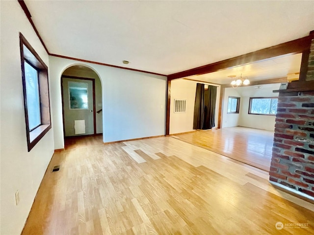 unfurnished living room with hardwood / wood-style flooring and an inviting chandelier