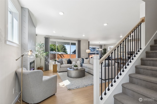 living room with stairway, light wood-type flooring, and recessed lighting