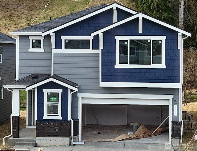 view of front of home with roof with shingles and an attached garage