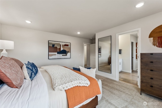 bedroom with ensuite bath and carpet flooring