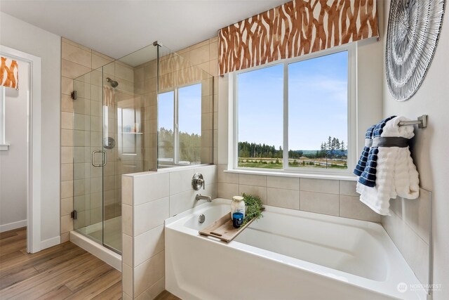 bathroom with hardwood / wood-style floors and shower with separate bathtub