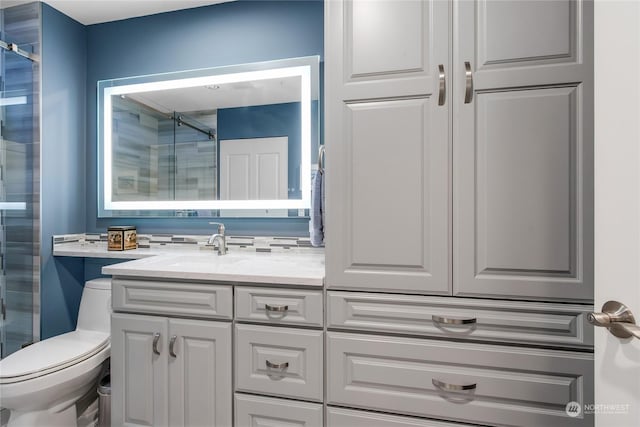 bathroom featuring vanity, toilet, and a shower with door