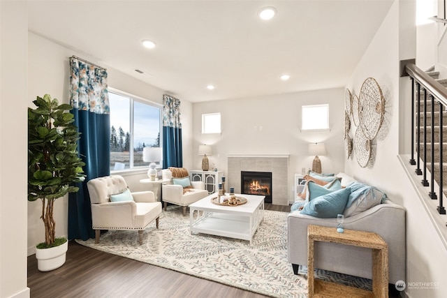 living room featuring hardwood / wood-style flooring and a tile fireplace