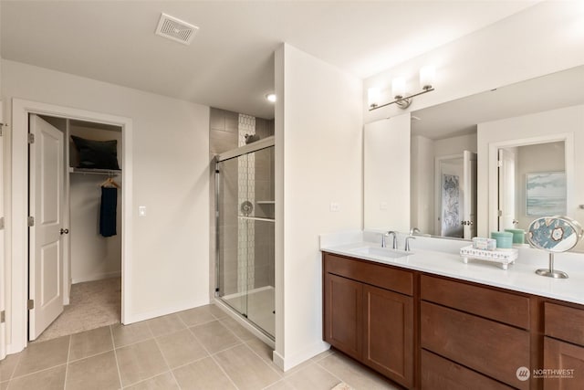 bathroom with vanity, tile patterned flooring, and walk in shower