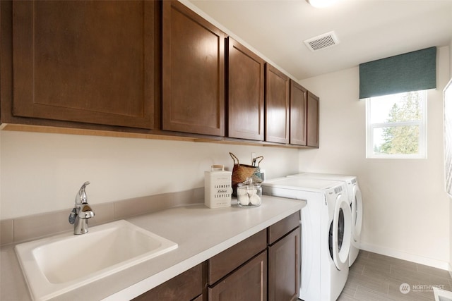 laundry area featuring cabinets, sink, and washing machine and clothes dryer