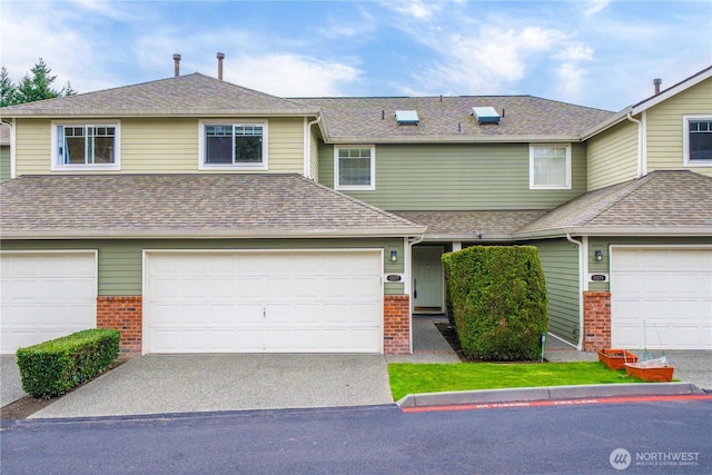 view of property featuring driveway, a garage, brick siding, and roof with shingles