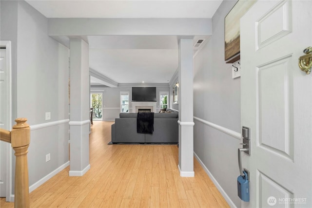 interior space featuring visible vents, a fireplace, light wood-type flooring, and baseboards