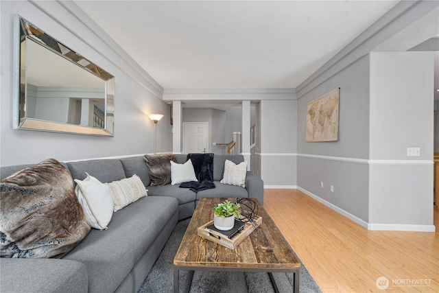 living area with baseboards and wood finished floors