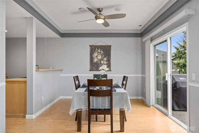 dining room with a ceiling fan, wood finished floors, and baseboards