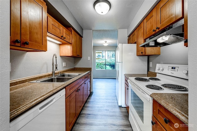 kitchen with sink, white appliances, a textured ceiling, and dark hardwood / wood-style floors