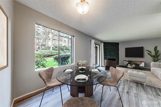 dining area featuring hardwood / wood-style flooring and a textured ceiling