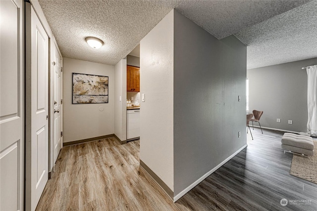 corridor featuring light hardwood / wood-style flooring and a textured ceiling