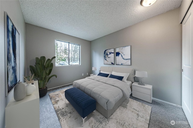 bedroom featuring a textured ceiling and carpet flooring