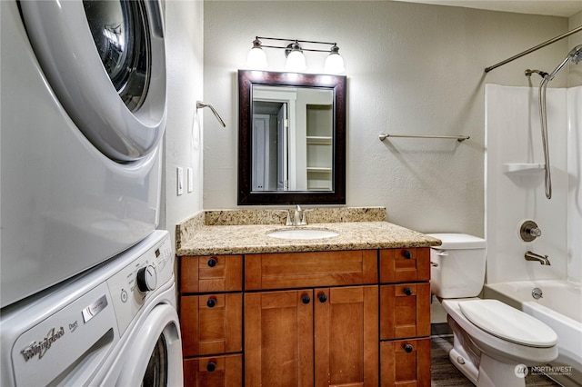 full bathroom with vanity, toilet, washtub / shower combination, and stacked washer and dryer