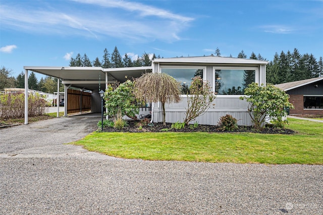 manufactured / mobile home with a front lawn and a carport