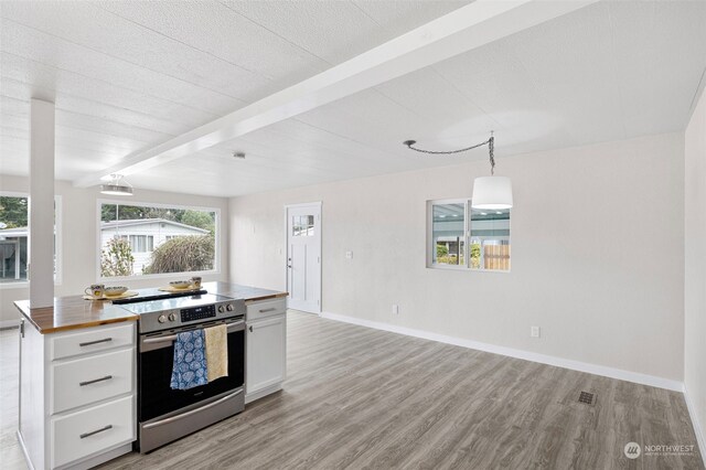 kitchen with hanging light fixtures, wooden counters, stainless steel electric range oven, white cabinetry, and beamed ceiling