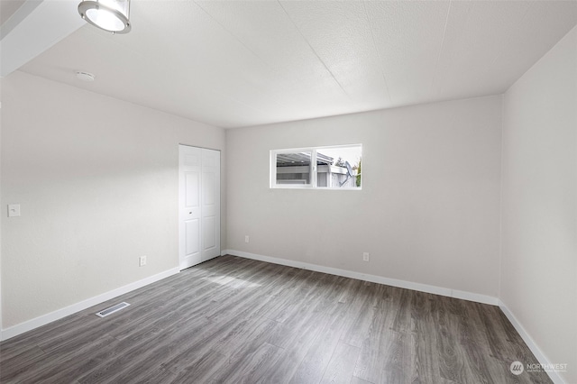 spare room with dark wood-type flooring