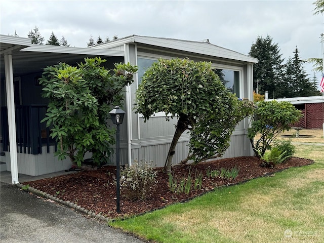 view of home's exterior featuring a yard and a carport