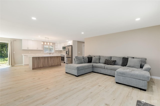 living room with sink and light wood-type flooring