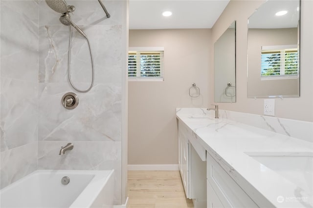 bathroom with vanity, hardwood / wood-style floors, and tiled shower / bath combo