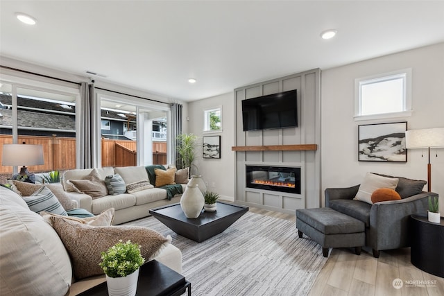 living room with light hardwood / wood-style floors and a large fireplace