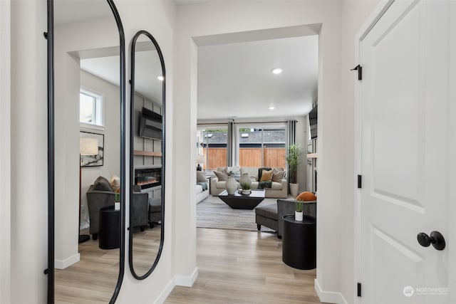 hall with light wood-type flooring and a wealth of natural light