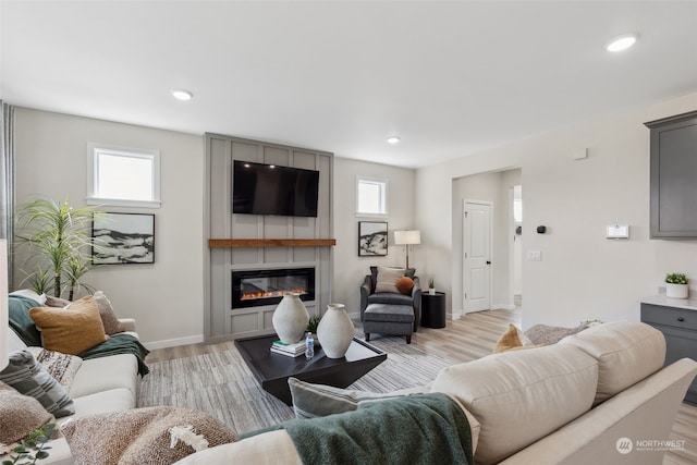 living room featuring light hardwood / wood-style floors and a large fireplace