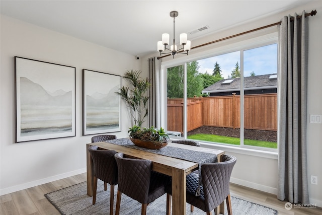 dining area featuring light hardwood / wood-style floors and a notable chandelier