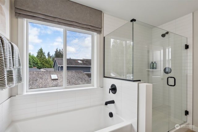 bathroom with a shower stall and a bath