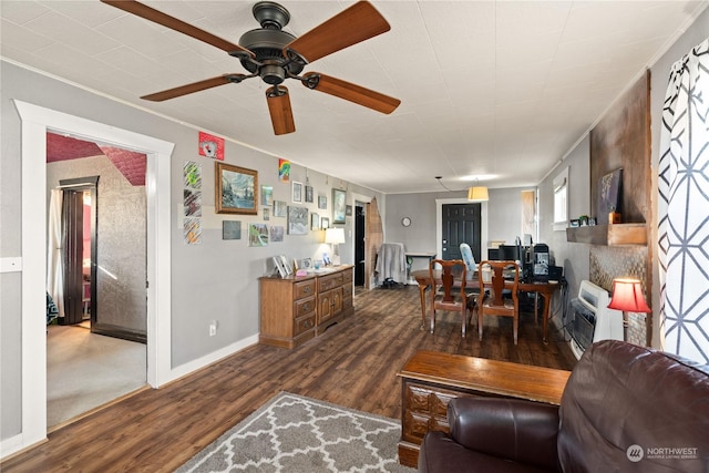 living room with heating unit, dark wood-type flooring, and ornamental molding