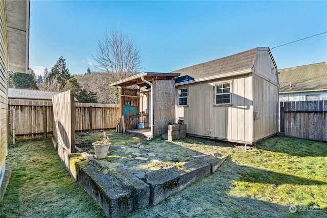 back of house with a yard and a shed