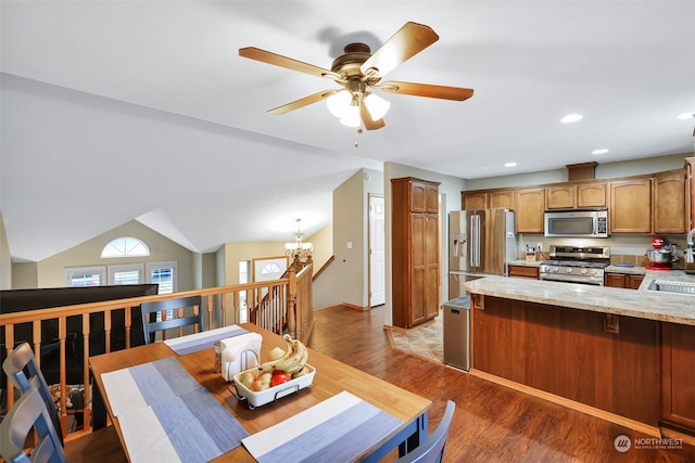 dining space featuring sink, an inviting chandelier, lofted ceiling, and light wood-type flooring