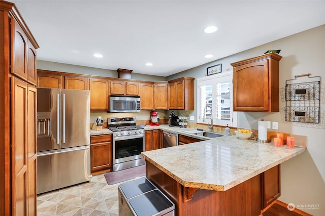 kitchen featuring sink, a breakfast bar area, kitchen peninsula, and appliances with stainless steel finishes