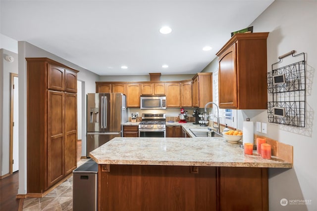 kitchen featuring sink, kitchen peninsula, and appliances with stainless steel finishes