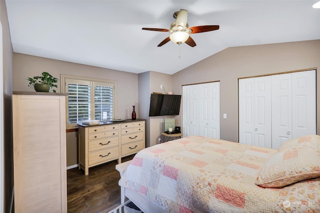 bedroom with ceiling fan, dark hardwood / wood-style flooring, lofted ceiling, and multiple closets