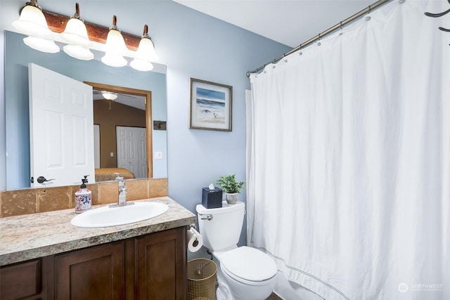 bathroom featuring vanity, toilet, and curtained shower