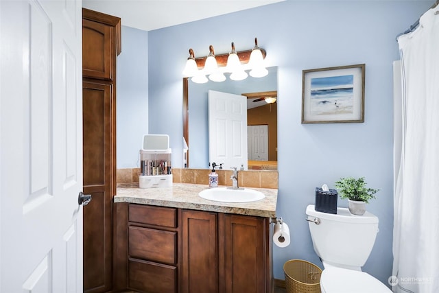 bathroom featuring vanity, toilet, and ceiling fan